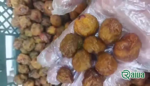Dried plums with a soft amber skin in a wooden bowl (view 1)