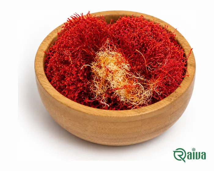 Bunches of red saffron filaments with their pale yellow styles, in a wooden bowl