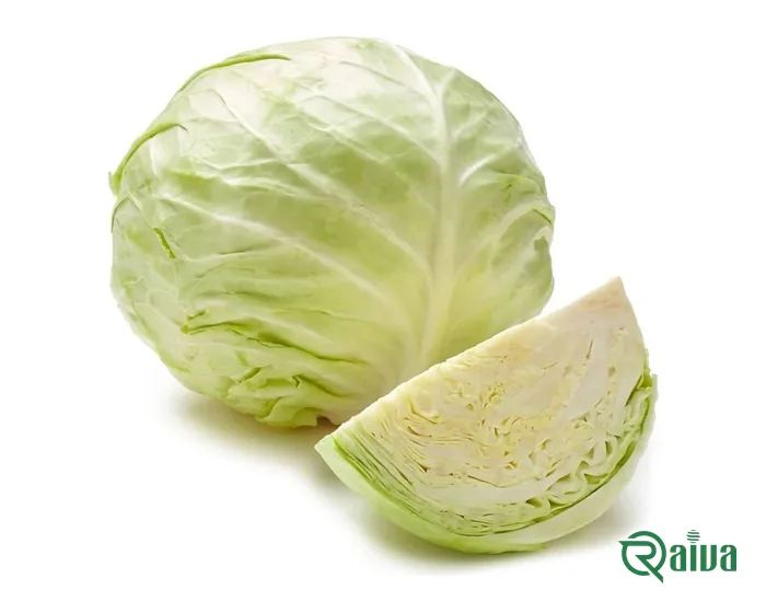 A head of green cabbage beside a cut wedge