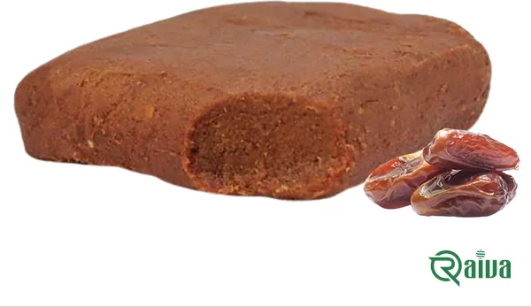 A pressed block of smooth brown date paste beside two whole dates (view 1)