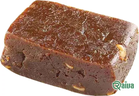 A pressed block of smooth brown date paste beside two whole dates (view 2)