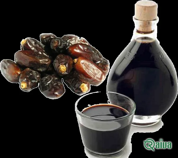Dark date syrup running from a spoon into a wooden bowl (view 2)
