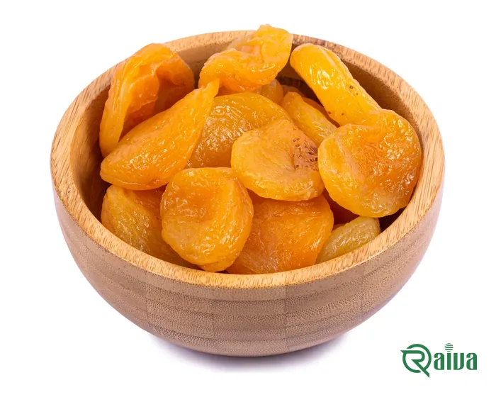 Orange dried apricot halves in a wooden bowl