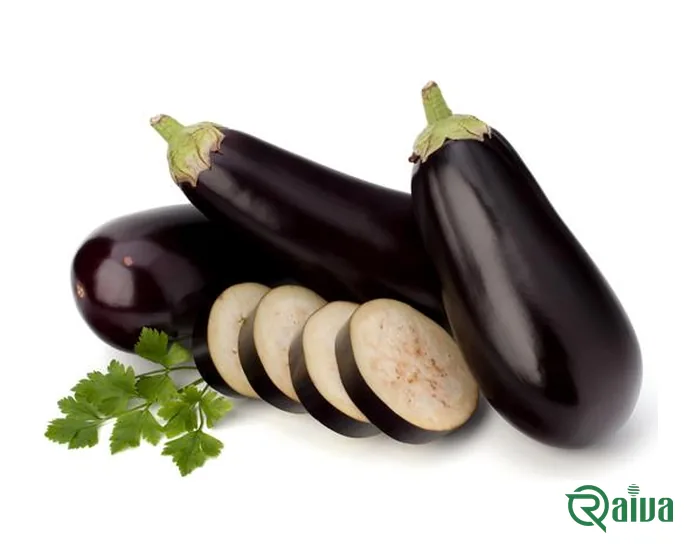 Glossy dark purple eggplants beside cut slices