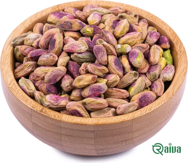 Shelled green pistachio kernels in a wooden bowl