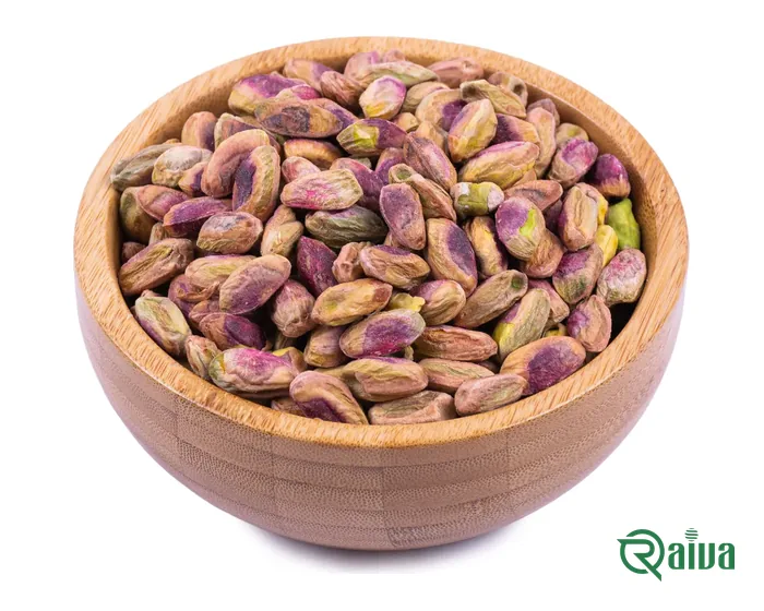 Shelled green pistachio kernels in a wooden bowl
