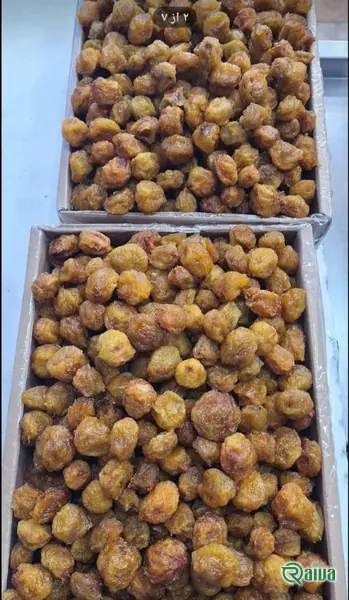 Dried plums with a soft amber skin in a wooden bowl (view 3)