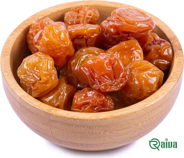 Dried plums with a soft amber skin in a wooden bowl (view 8)