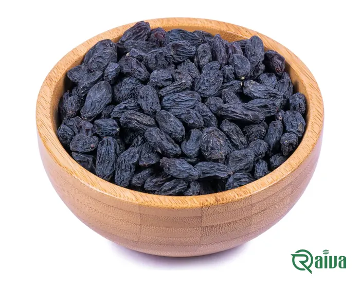 Dark seedless black raisins in a pale bowl